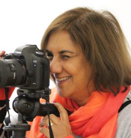 Woman looking through viewfinder on digital camera on tripod