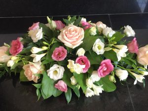 Flower arrangement with pink roses and white fresias