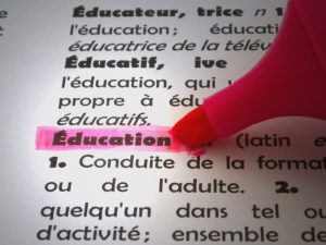 Page of french dictionary with pink highlighter on word Education