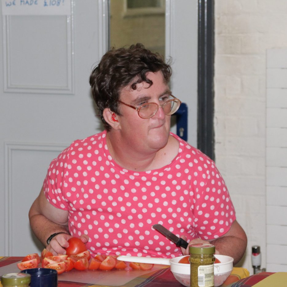 Woman in pink top cutting tomatoes