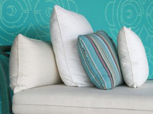 Turquoise and cream cushions on a chaise longue