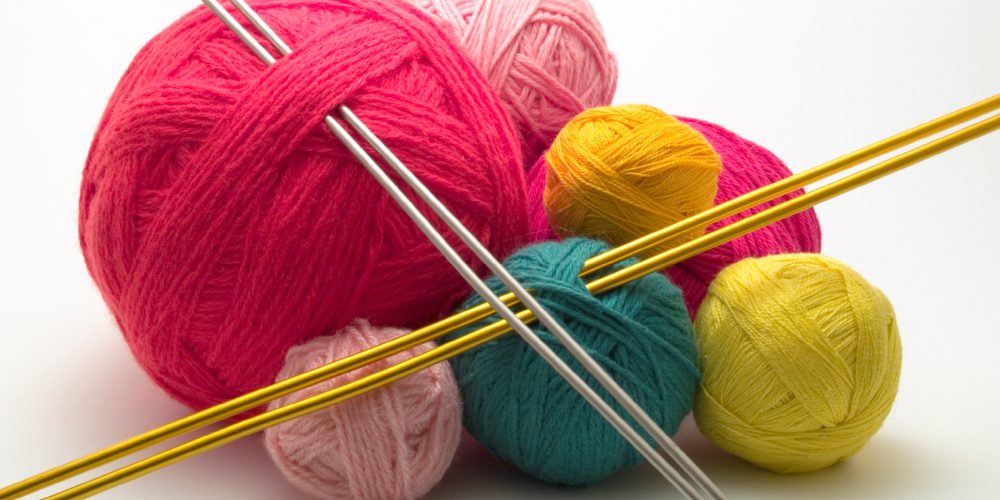 Balls of coloured wool with knitting needles