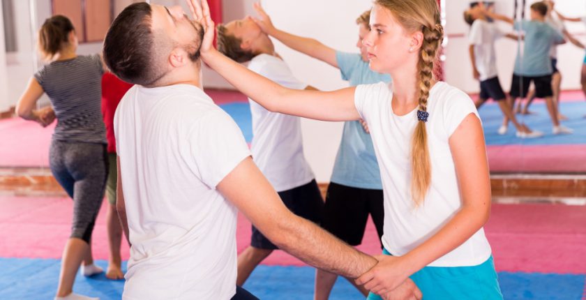 Girl and man practising self-defence techniques