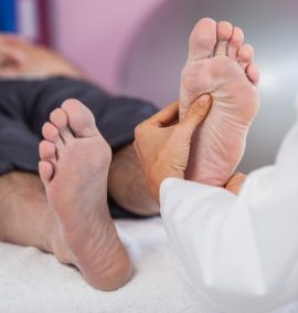 person practising reflexology on a man's feet
