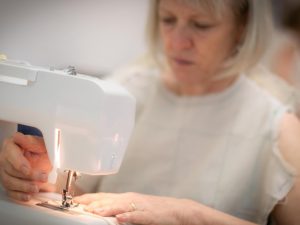 Woman in muslin pattern using sewing machine