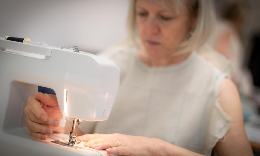 Woman in muslin pattern using sewing machine