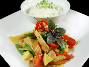 Thai red curry and bowl of rice on white square plate