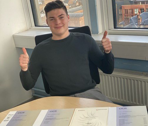 Young man with thumbs up and apprenticeship certificates