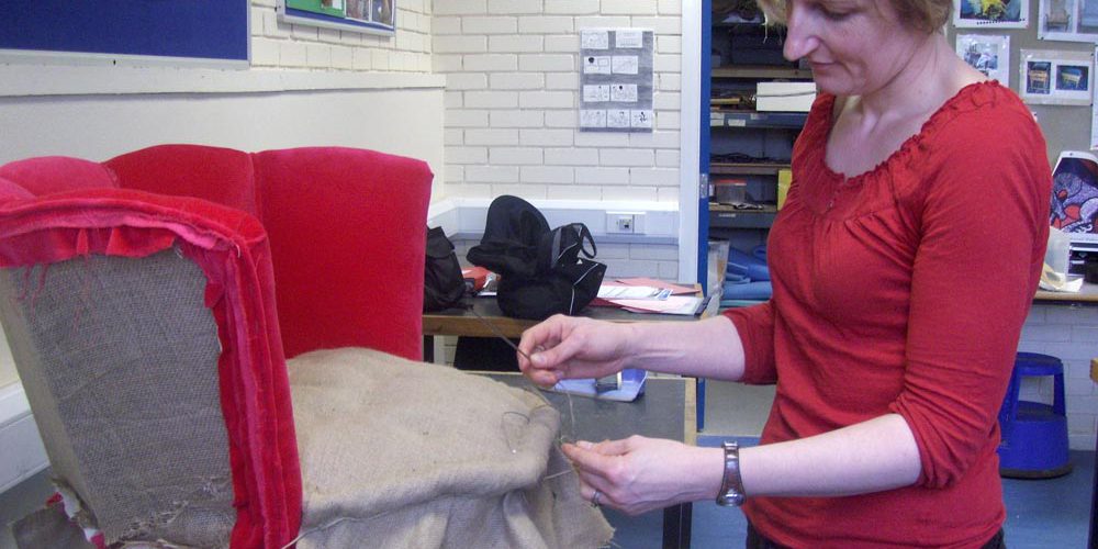 Woman reupholstering a chair