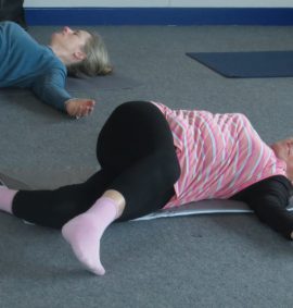 Two women lying down on yoga mats