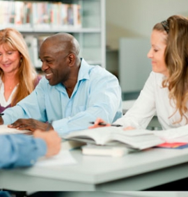 Two women and one man smiling whilst in a lesson